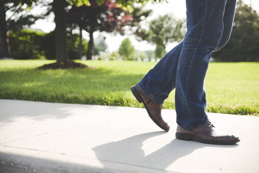 Une personne marchant sur un trottoir