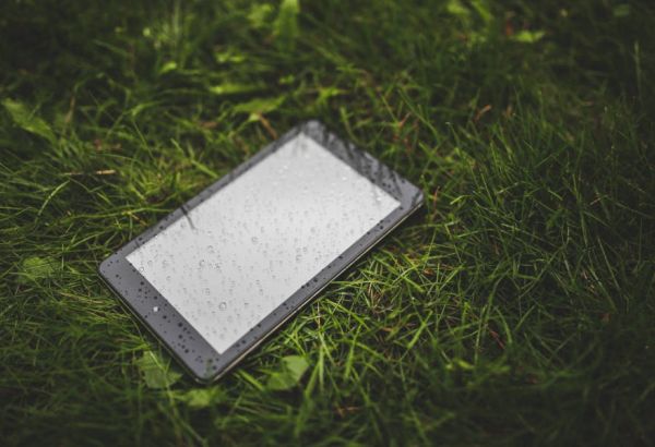 Un smartphone ou une tablette dans l'herbe